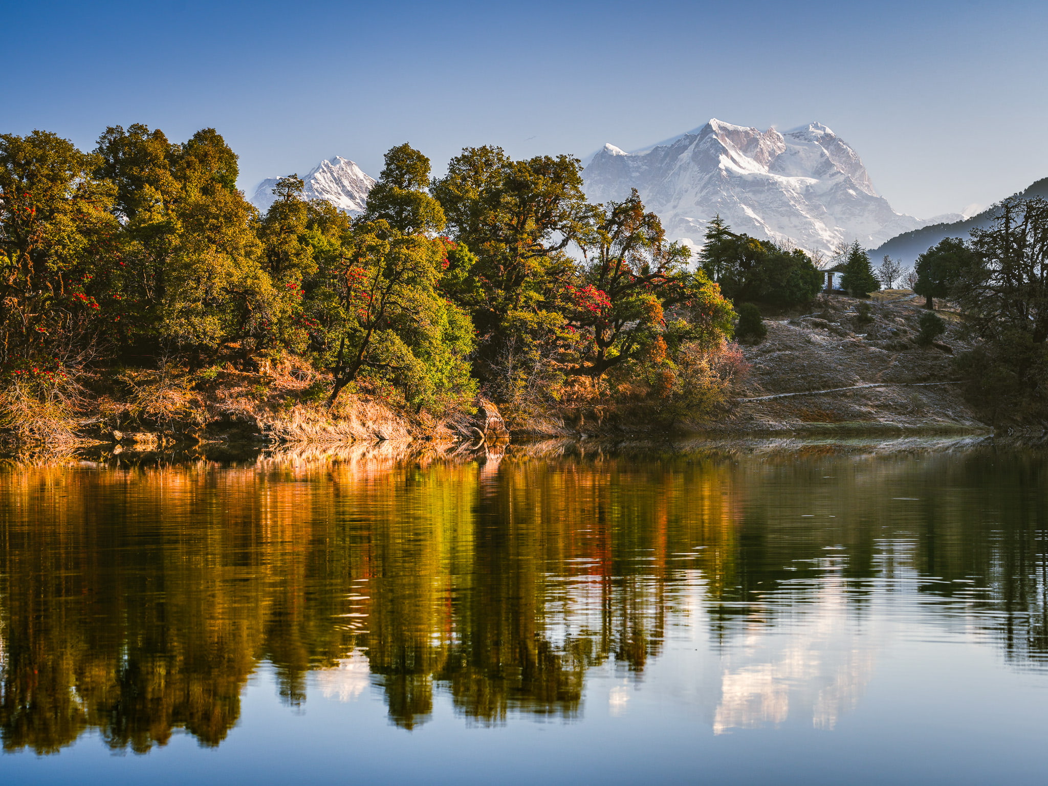 Alpine lake reflecting Himalayan peaks at first light