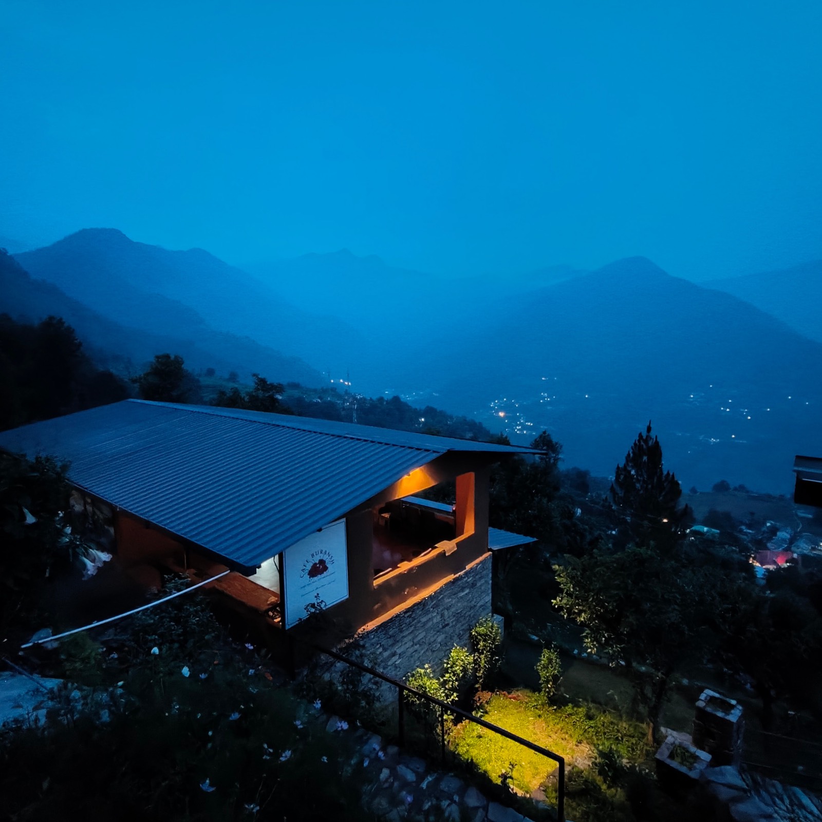 Snow-capped Himalayan peaks at sunrise above a forested valley