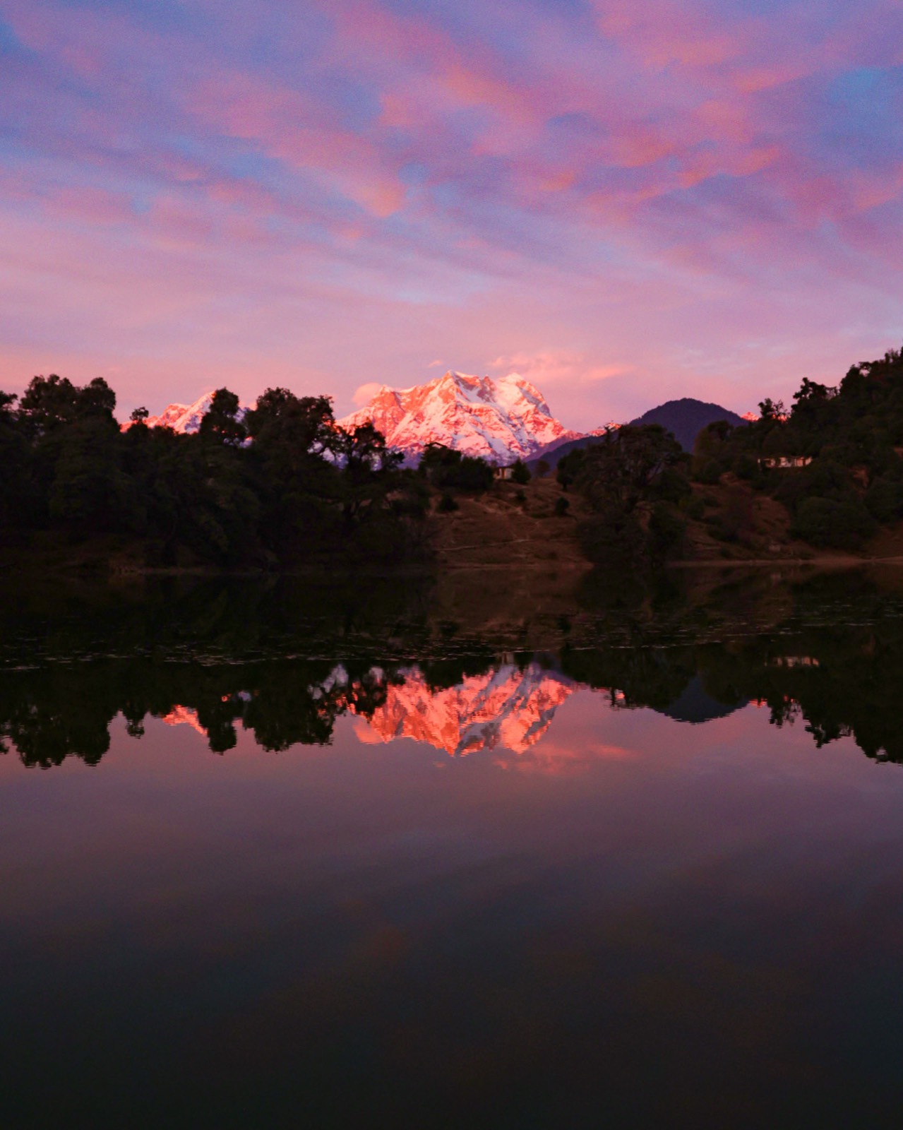 Alpine lake reflecting Himalayan peaks at first light
